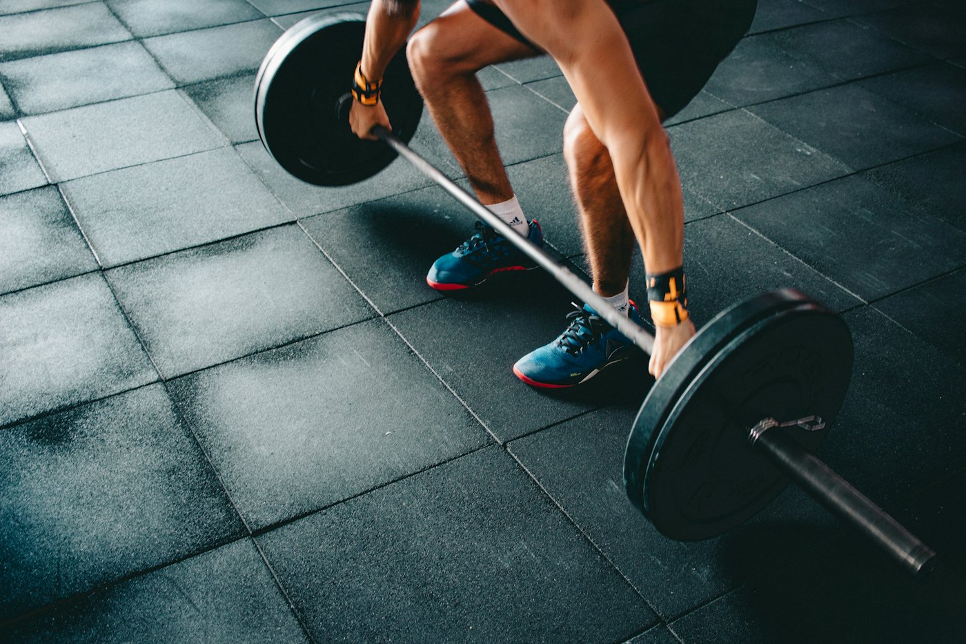 A person holding a barbell in a deadlift setup