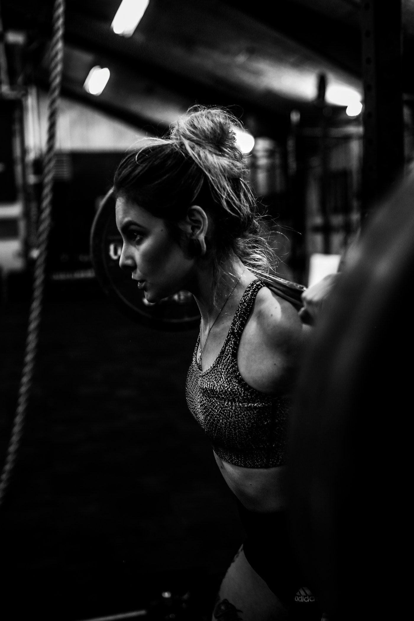 A person holding a barbell across the shoulders while another person spots the lift