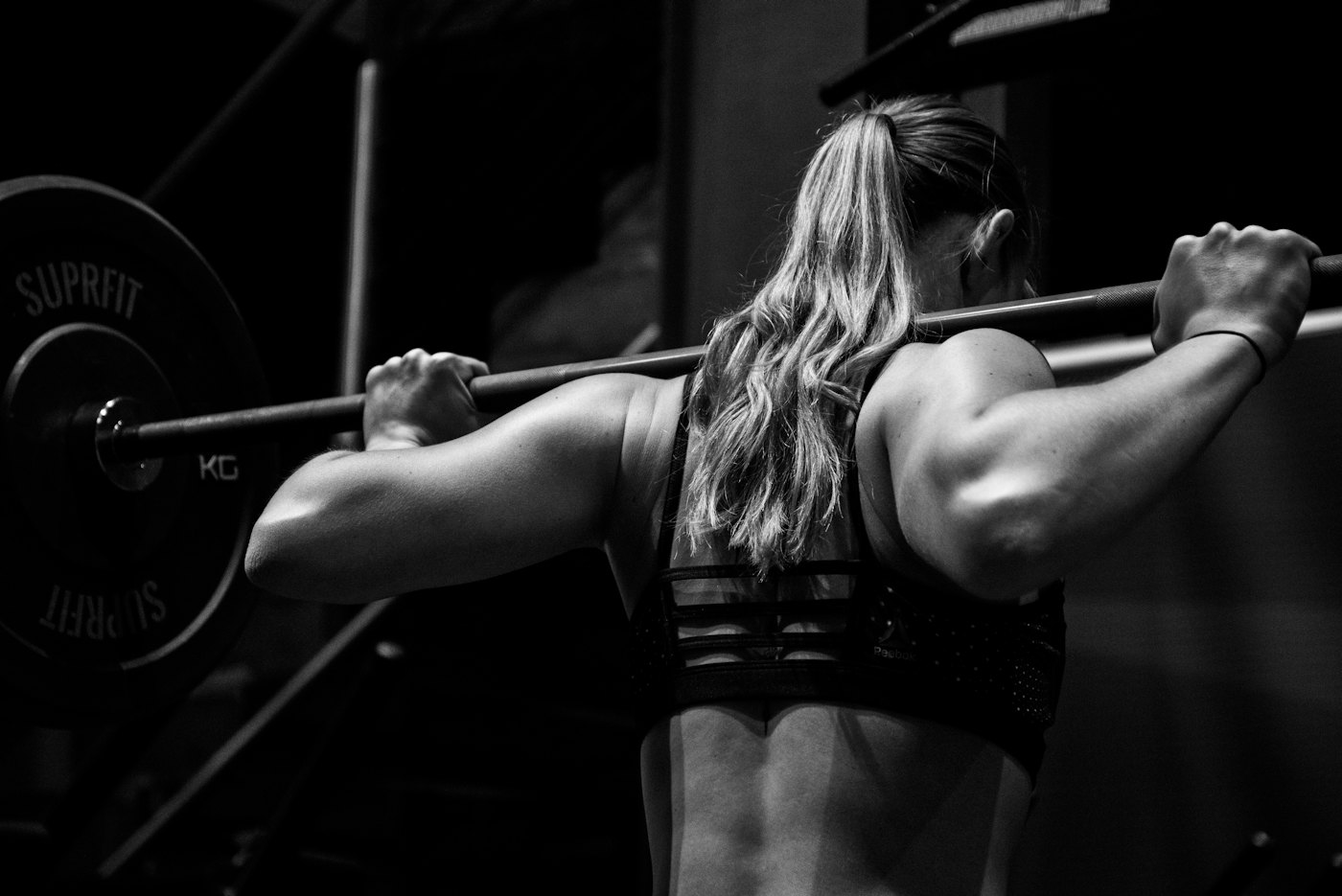 A person with a barbell across the upper back